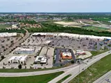Exterior aerial view of parking area and multiple businesses within Central Texas Marketplace