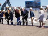8 members of the Ball Ventures leadership team in hardhats shoveling up dirt at groundbreaking ceremony